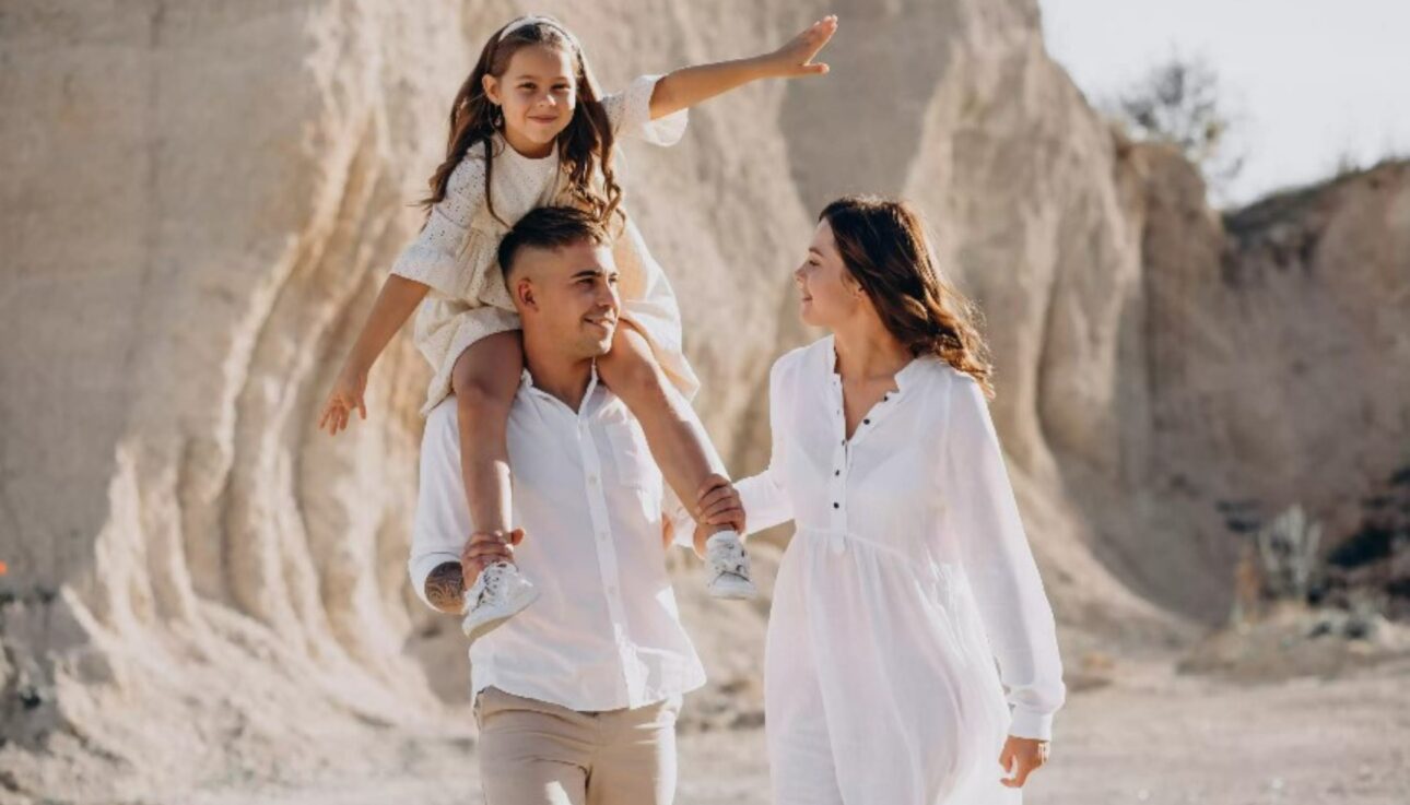 Happy family walking in the Moroccan desert with their chlid during a family-friendly travel experience
