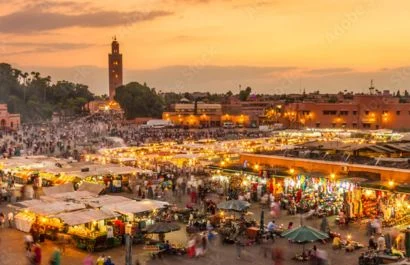 jemaa el-fna square at sunset with food stalls and crowd in Marrakech, Morocco