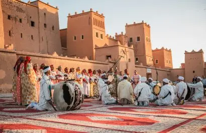Traditional Moroccan folklore music and dance performance in front of a historic Kasbah